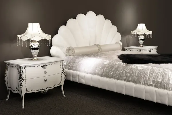 Moderna möbler. säng med lurviga counterpane och lampor på bedsid — Stockfoto