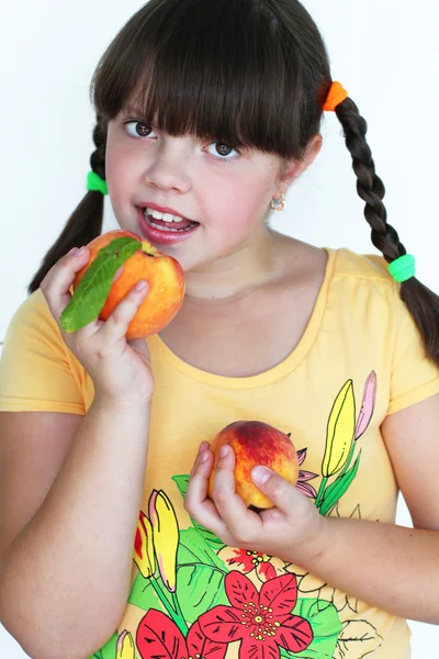 Happy Beautiful little girl holding tasty peaches — Stock Photo, Image