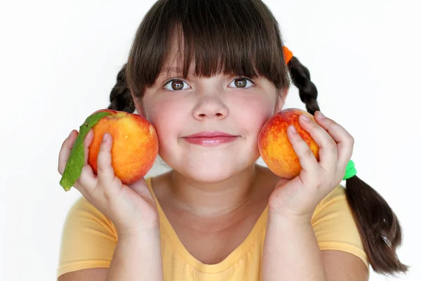 Porträtt söt flicka med två persika isolerad på vit bakgrund — Stockfoto