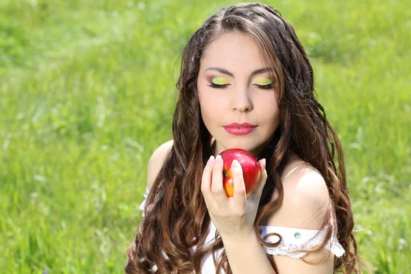 Beautyful woman present apples.Go to you on the Nature