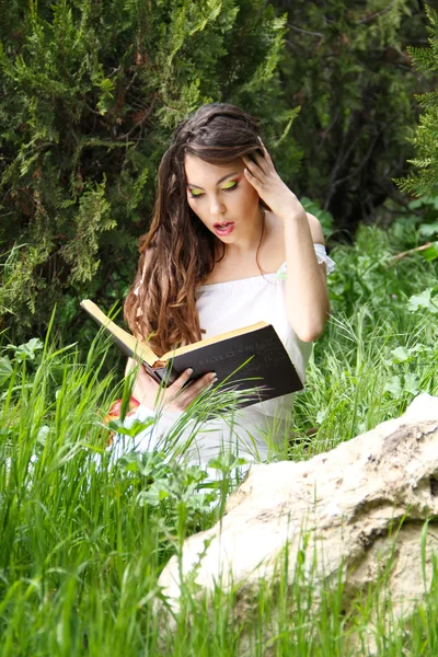 年轻漂亮的女孩读一本书户外 — 图库照片