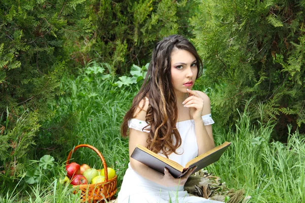Молодая красивая девушка читает книгу на открытом воздухе — стоковое фото