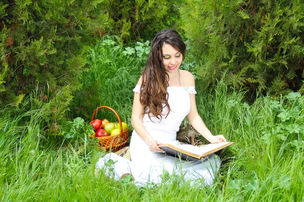 Joven hermosa chica leyendo un libro al aire libre — Foto de Stock