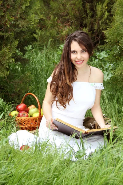 Lächelnde schöne Frau las das Buch über die Natur. Garten — Stockfoto