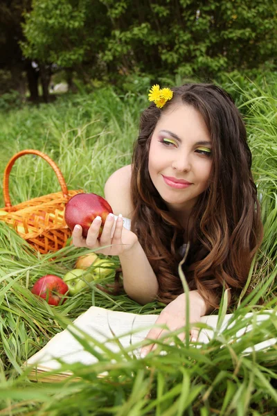 Портрет красивих молодих жінок з червоним яблуком на зеленому полі — стокове фото