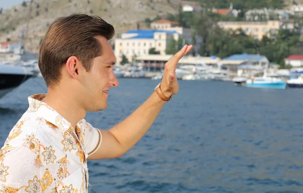 Guy waving his hand at sea, greeting — Stock Photo, Image