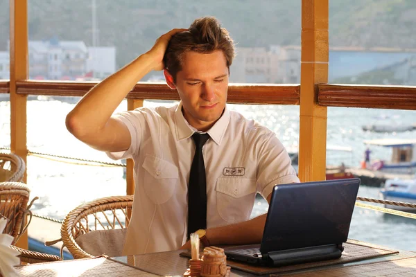 Pohledný muž podnikatel práce na notebooku v restauraci — Stock fotografie