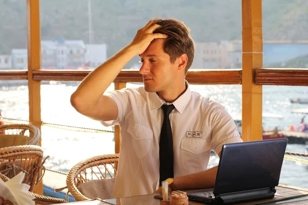 Pohledný muž podnikatel práce na notebooku v restauraci — Stock fotografie