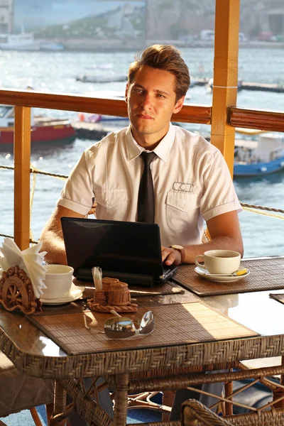 Homem bonito homem de negócios trabalhar no laptop no restaurante — Fotografia de Stock