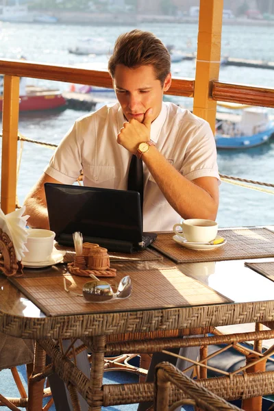 Hombre guapo hombre de negocios trabajo en el portátil en el restaurante —  Fotos de Stock