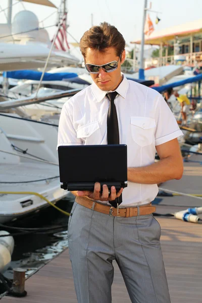 Όμορφος άντρας, μια σοβαρή καπετάνιος σε ένα λευκό πουκάμισο κοντά στο σκάφος, ψάχνει aw — Φωτογραφία Αρχείου