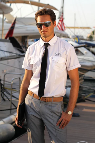 Przystojny mężczyzna, poważny kapitan w białej koszuli w pobliżu jachtu, wygląd aww — Zdjęcie stockowe