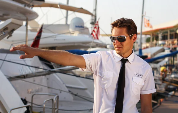 Красивий чоловік, серйозний капітан у білій сорочці біля яхти, дивлячись — стокове фото