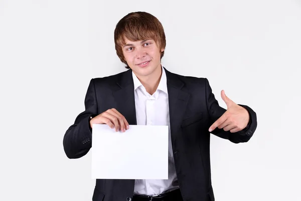 Porträt eines lächelnden jungen Geschäftsmannes mit einer leeren Plakatwand, Hand — Stockfoto