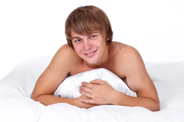 Joven sexy hombre acostado en la cama blanca — Foto de Stock