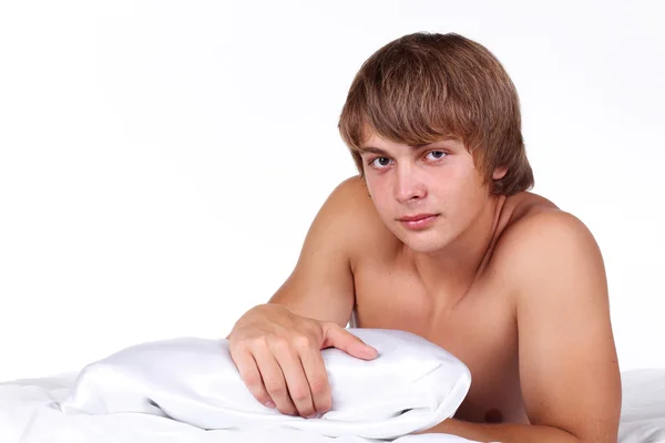 Young sexy man lying on white bed — Stock Photo, Image