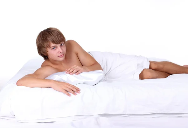 Młody seksowny mężczyzna leżał na białe łóżko — Zdjęcie stockowe