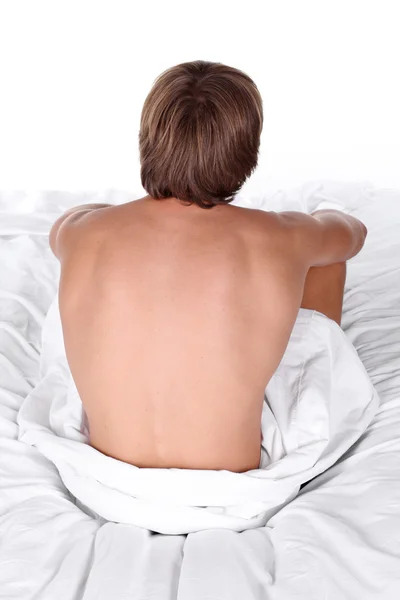 Junger sexy Mann liegt auf weißem Bett — Stockfoto
