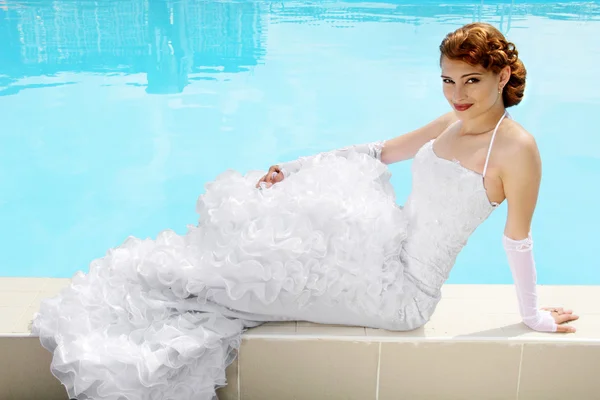 Bella donna in abito da sposa. piscina — Foto Stock