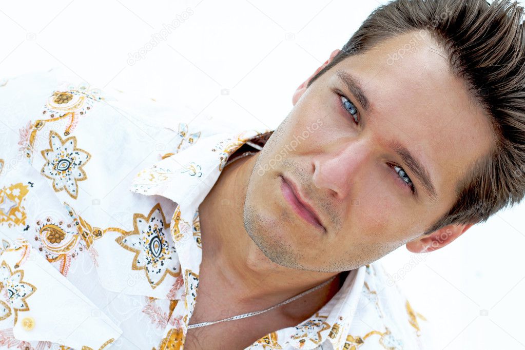 Portrait of handsome man with blue eyes on the beach, white ya