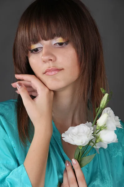 Retrato de una hermosa chica oriental con flores en la mano —  Fotos de Stock