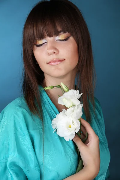 Retrato de una hermosa chica oriental con flores en la mano —  Fotos de Stock