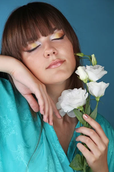 Retrato de una hermosa chica oriental con flores en la mano — Foto de Stock