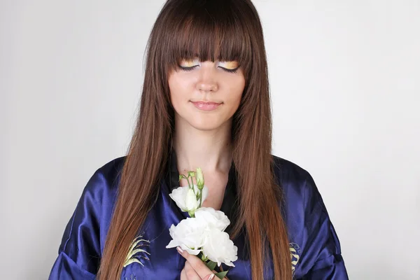Portret piękne orientalne dziewczyny z kwiatami w ręku — Zdjęcie stockowe