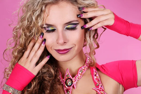 Make-upu, portrét krásná žena na růžovém pozadí — Stock fotografie