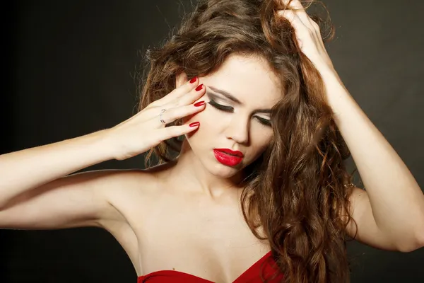 Sensuella dam med röda läppar och röda naglar, röra ansiktet — Stockfoto