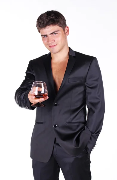 Homem de negócios em terno preto segurando vidro de conhaque isolado em w — Fotografia de Stock