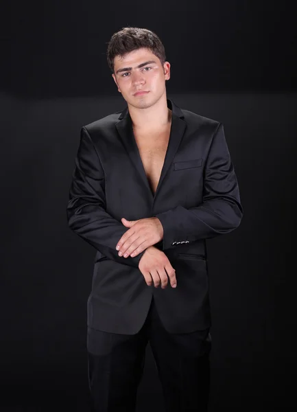 Bonito homem elegante em terno preto elegante isolado no bac escuro — Fotografia de Stock