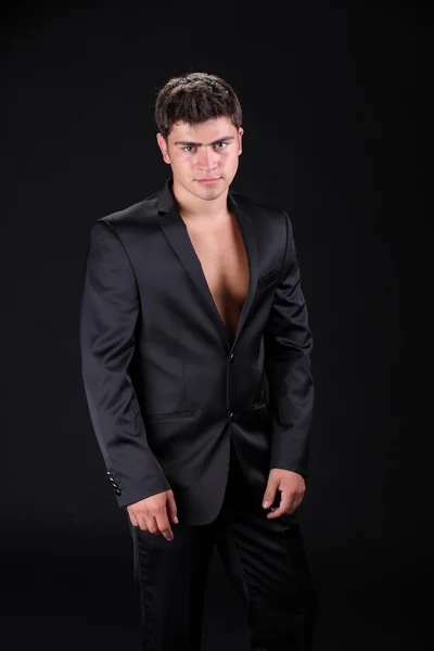 Bonito homem elegante em terno preto elegante isolado no bac escuro — Fotografia de Stock