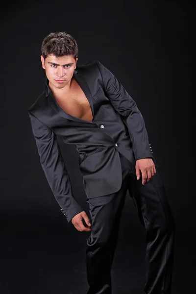 Przystojny stylowy mężczyzna czarny elegancki komplet na białym tle na ciemny bac — Zdjęcie stockowe