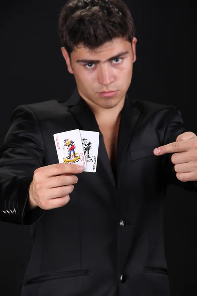 Крутой молодой человек с четырьмя тузами, тасует карты — стоковое фото