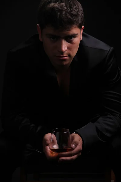 Człowiek obecny kieliszek koniaku na ciemnym tle, biznes — Zdjęcie stockowe