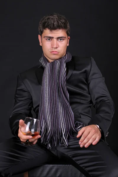 Man med glas cognac på mörk bakgrund — Stockfoto