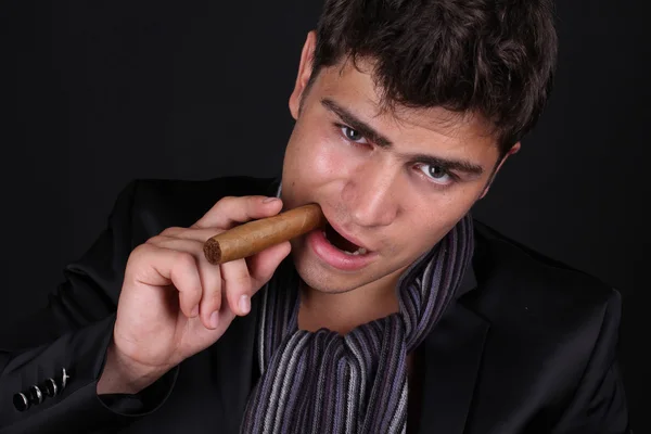Pohledný muž držící doutník s kouřem — Stock fotografie