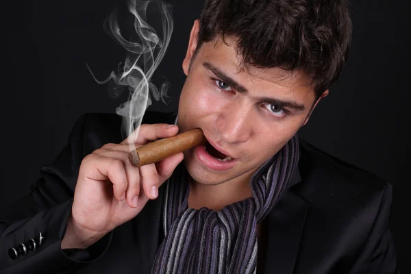 Hombre guapo sosteniendo cigarro con humo — Foto de Stock