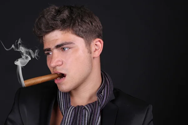 Красивый мужчина держит сигару с дымом — стоковое фото