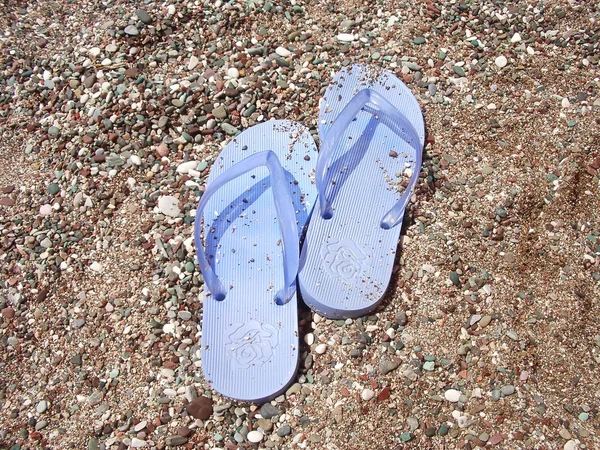Strand sandalen naar het kiezelstranden strand Stockfoto