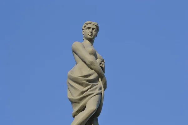 Estatua de una mujer sobre fondo azul del cielo — Foto de Stock