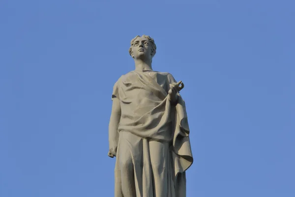 Estatua de una mujer sobre fondo azul del cielo — Foto de Stock