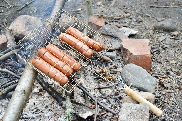 Enchidos grelhados sobre carvão vegetal no fogo da grelha — Fotografia de Stock