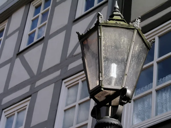 stock image An old-fashioned street lamp in front of a typical German facade