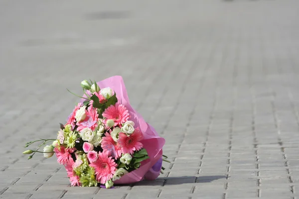 Stock image Bridal bouquet of flowers lay on the sidewalk