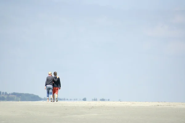 หนุ่มสาวสองคนเดินผ่านทะเลทราย — ภาพถ่ายสต็อก
