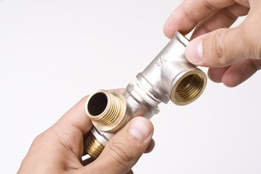 Connectors of plumbing pipes in the hands clipart