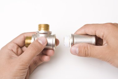 Connectors of plumbing pipes in the hands clipart