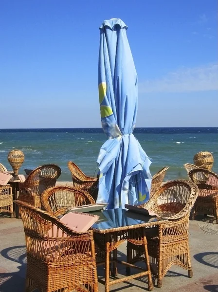 Cafe on sea shore, blue umbrellas — Stock Photo, Image